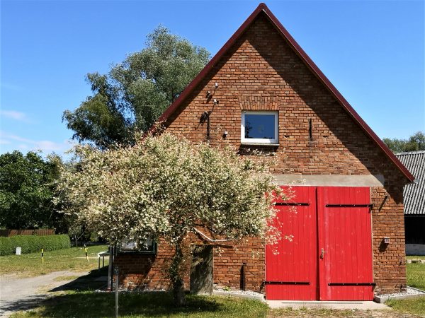 Ein altes Haus mit rotem Scheunentor.