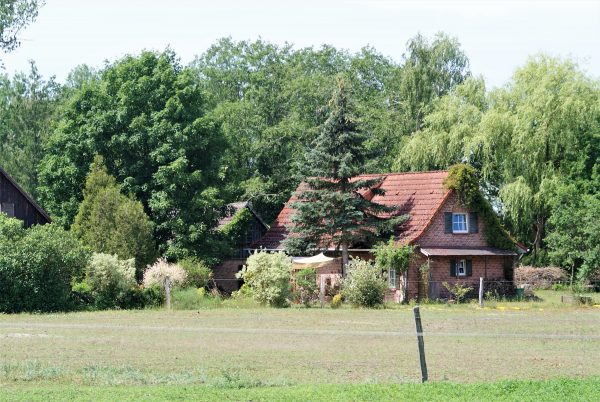 Ein kleines Haus am Rand einer Pferdekoppel.