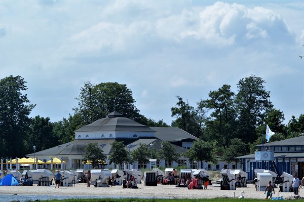 Die historische Strandhalle des Hafbads in Ueckermünde mit vielen Badegästen.