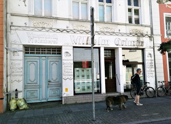 Ein Mann geht mit seinem Hund durch die Altstadt von Ueckermünde.