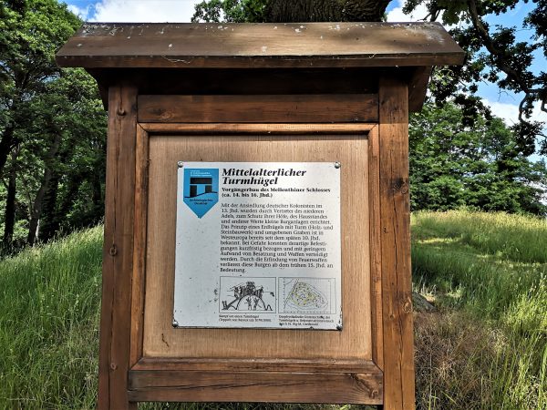 Eine Infotafel informiert über die Reste eines mittelalterlichen Turmhügels.