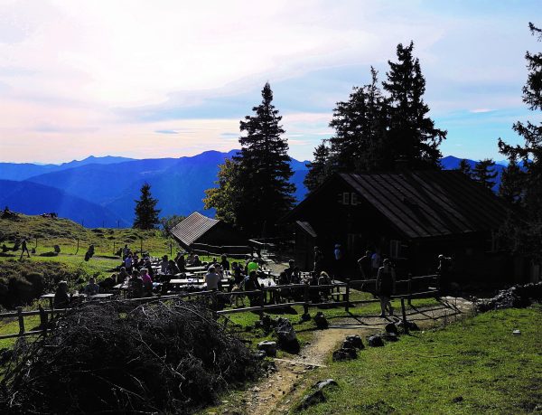 Eine urige alte Hütte auf einem Berg. Viele Menschen kehren hier ein.