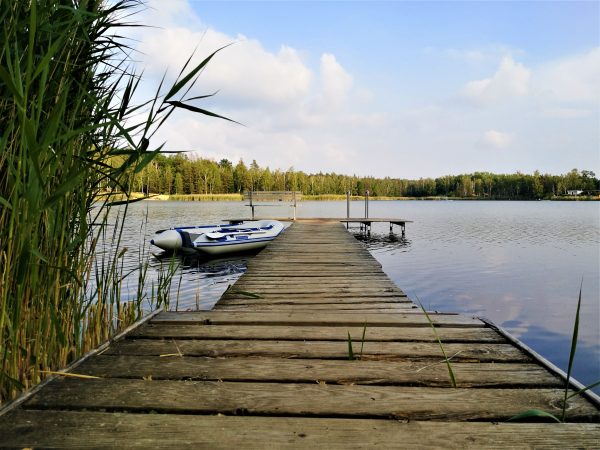 Ein Badesteg mit einem Boot ragt in einen See.