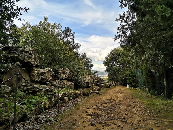 Ein Wanderweg führt an Mauern entlang.
